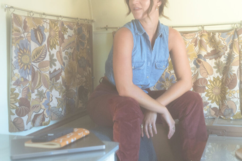 A copywriter sits in a trailer with her copywriting vs. content writing journal sits next to her.