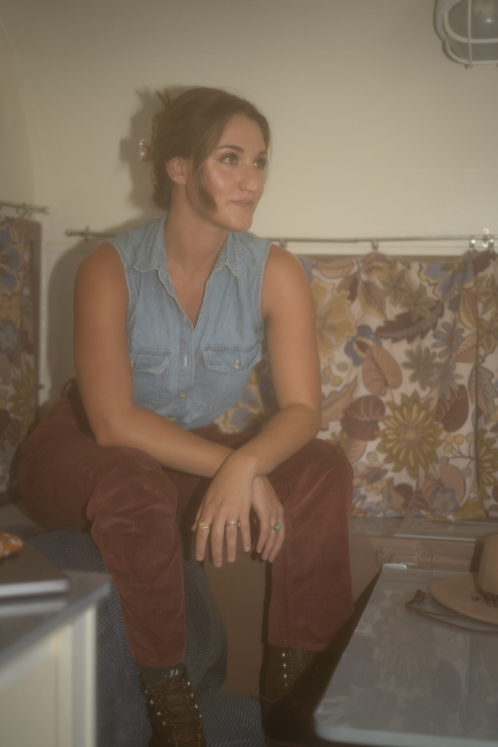 A sales copywriter for small business sits on the table inside a 1970s travel trailer.