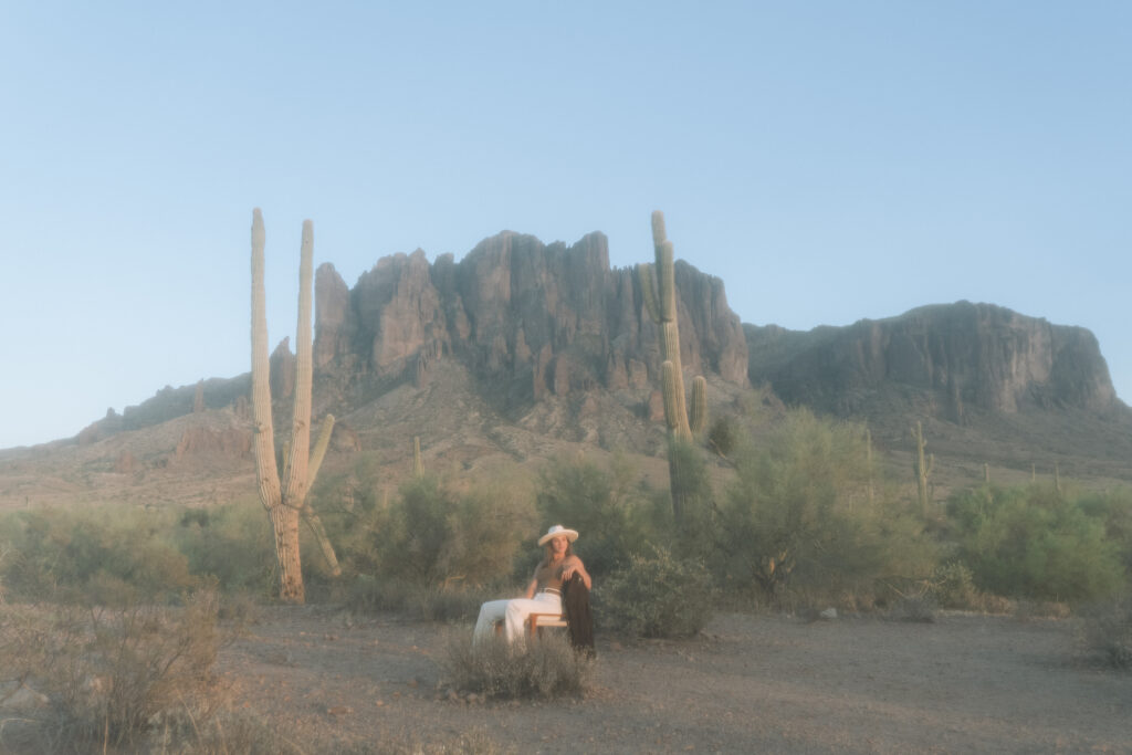 A blogging copywriter sits on a chair in the Arizona desert, looking out in to the empty landscape.