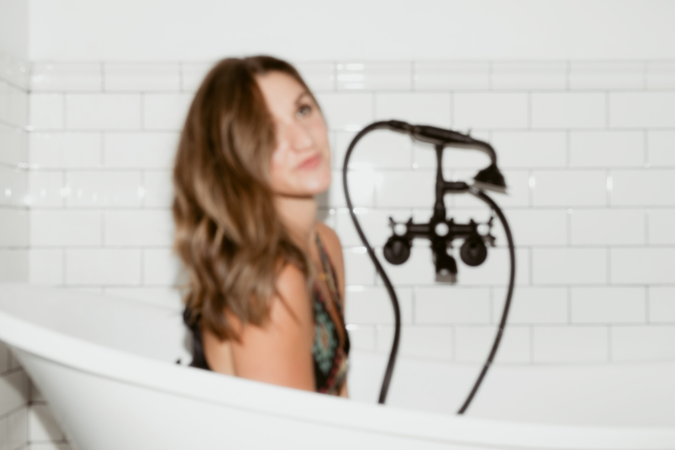 A blogging copywriter poses in the bathtub during a brand photo shoot.